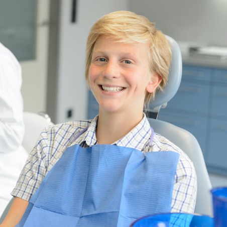 Young boy smiling after emergency dentistry